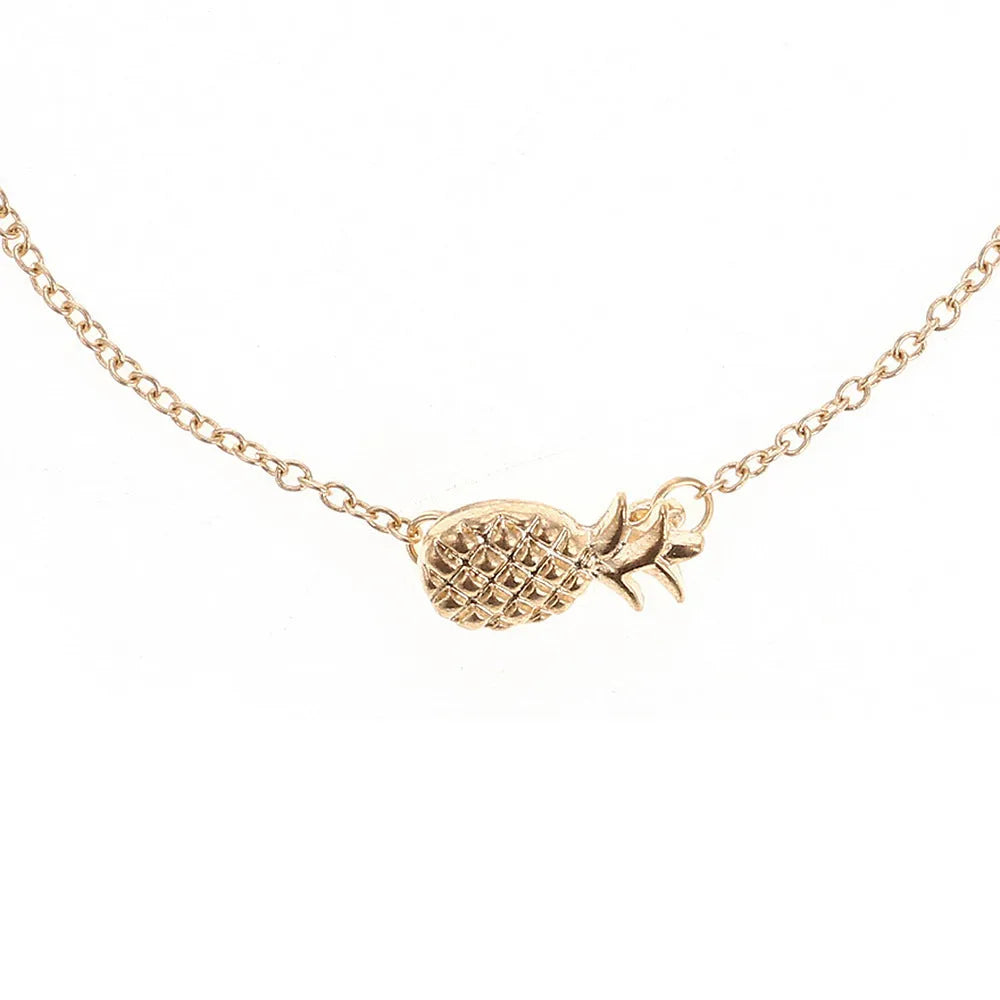 Gold and silver alloy pineapple charm bracelet on wrist, showing adjustable clasp.