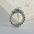Pair of antique silver dragon-shaped hollow-out earrings with geometric design on a white background