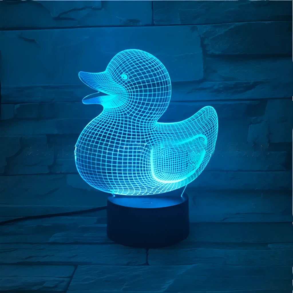 Little Yellow Duck shaped 3D acrylic night light with remote control on a table.