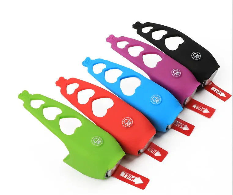 Bicycle electronic horn with plastic casing in multiple colours including black, green, purple on bicycle handlebars