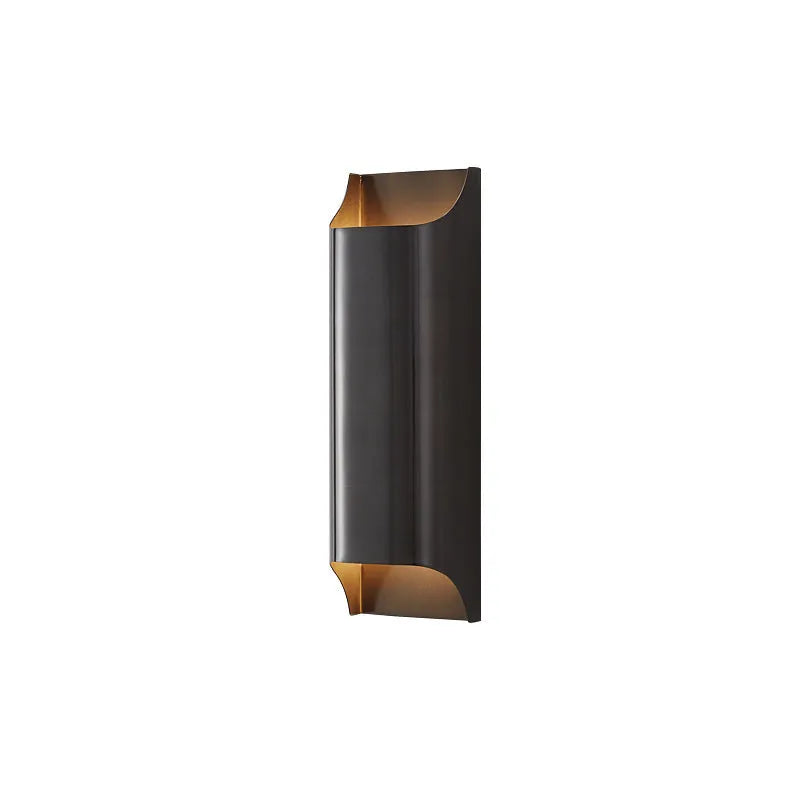 Minimalist copper wall lamp with black gold finish mounted beside bed