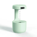 Rose gold and white columnar humidifier with levitating water drops and LED lighting on desk