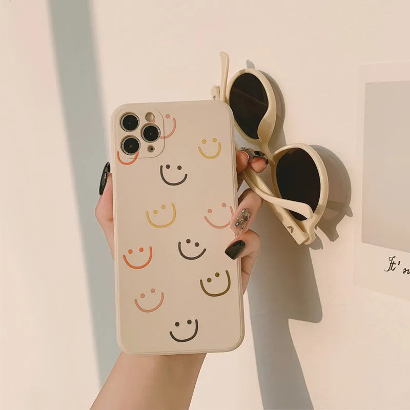 Painted silicone iPhone case showing smiley, rainbow, and watercolour design options