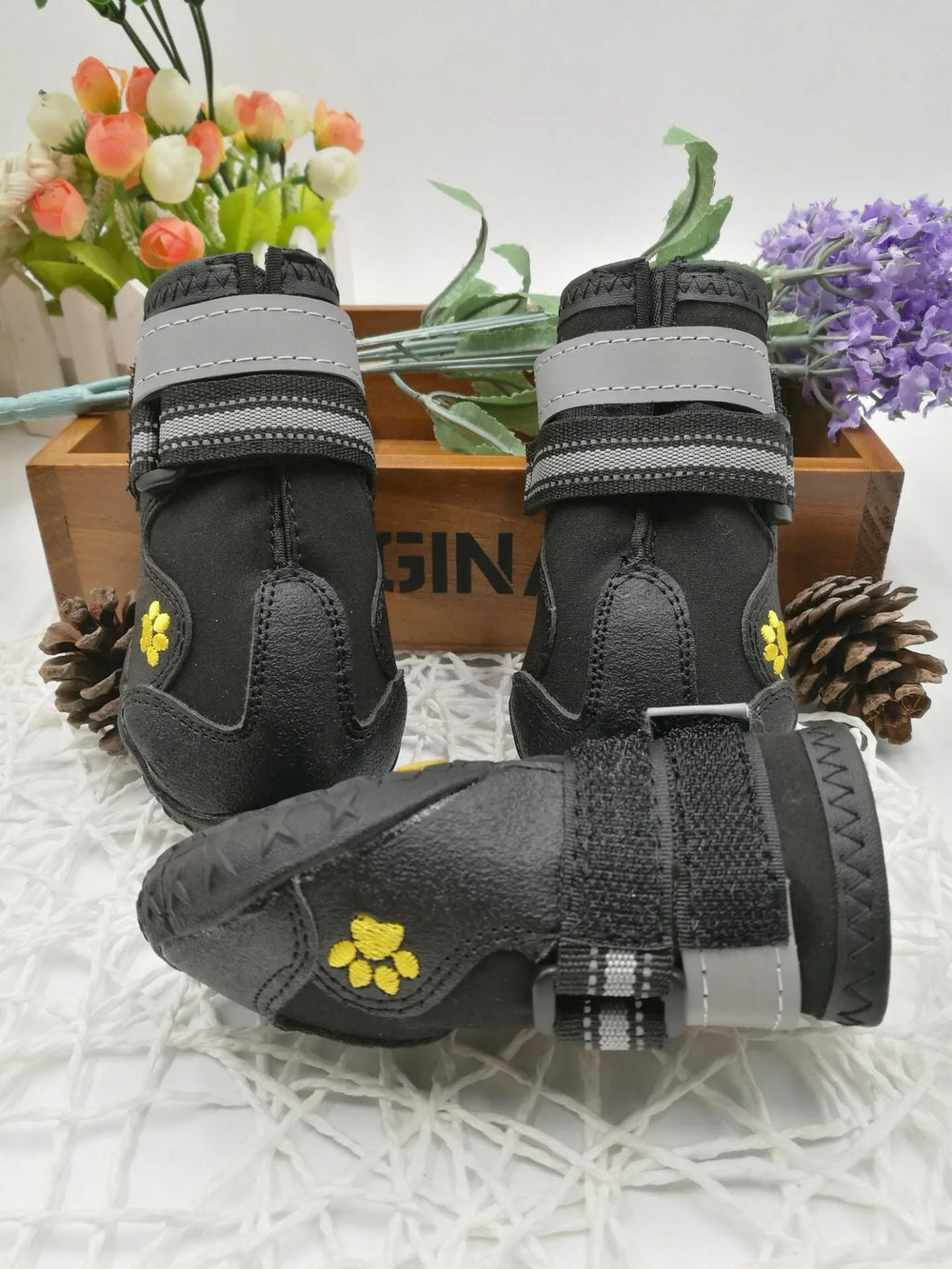 Black pet dog shoes with waterproof PVC sole and adjustable fuzzy belt on a light background