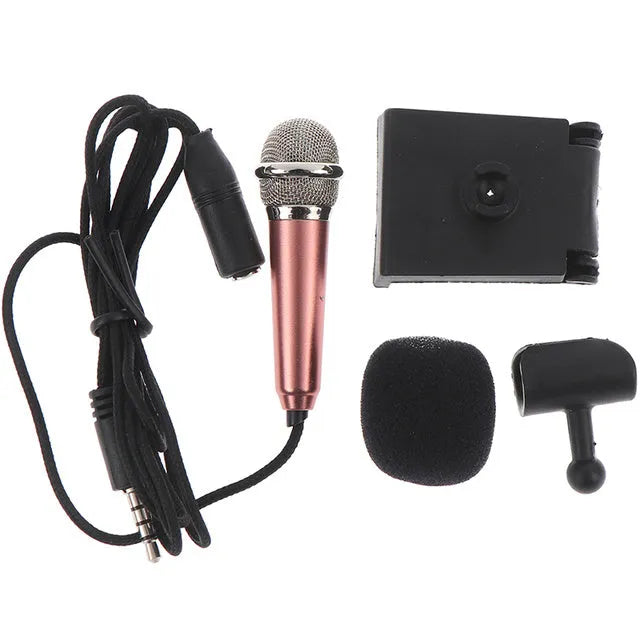 Portable 3.5mm mini karaoke microphone in rose gold with sponge head and stand on a table