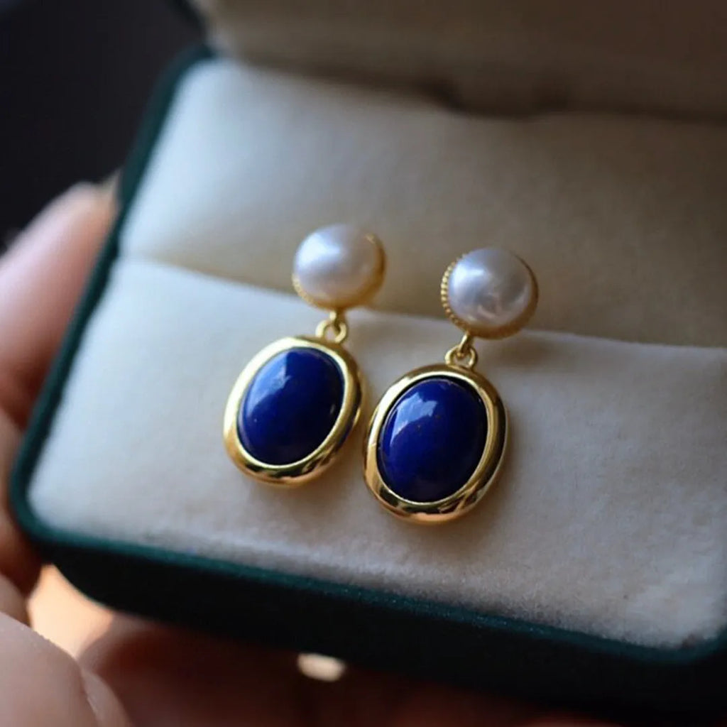 A pair of simple stud earrings with blue lapis lazuli pearls set in silver backs.