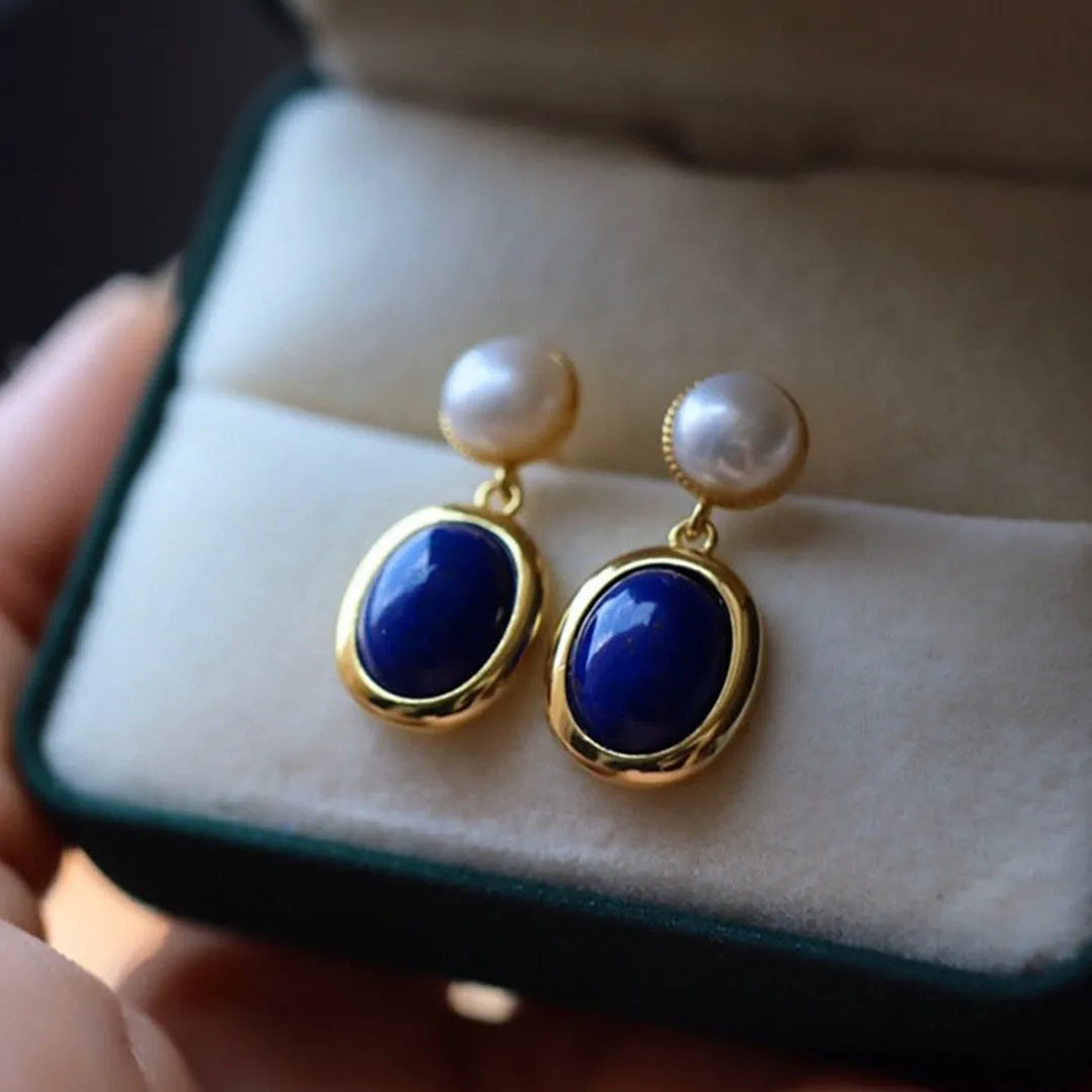 A pair of simple stud earrings with blue lapis lazuli pearls set in silver backs.