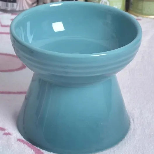 White ceramic pet bowl with a high foot base and wide, shallow eating area for dogs and cats