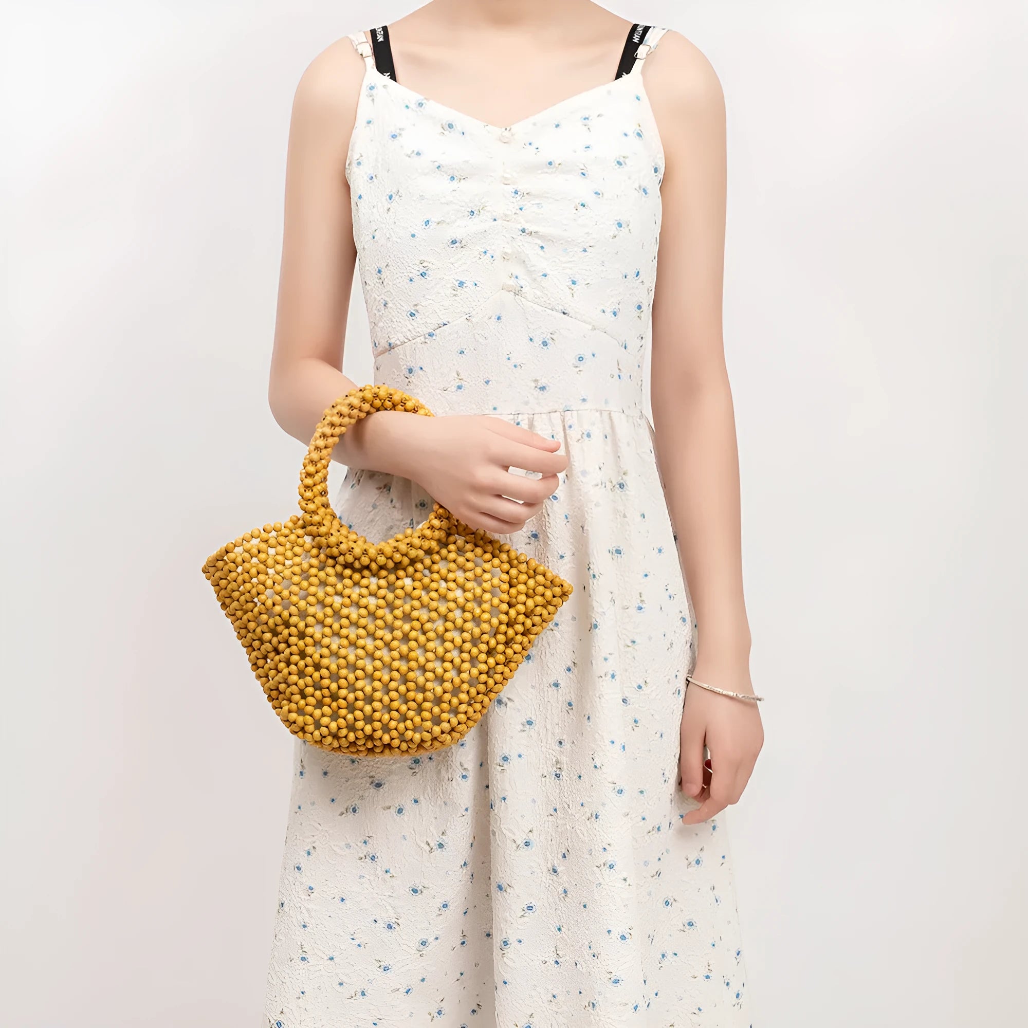 Hand-woven wooden bead beach bag in dumpling shape with strapless design.