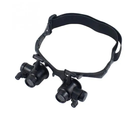Black double eye magnifier glasses with LED lights and four sets of interchangeable lenses on a headband.