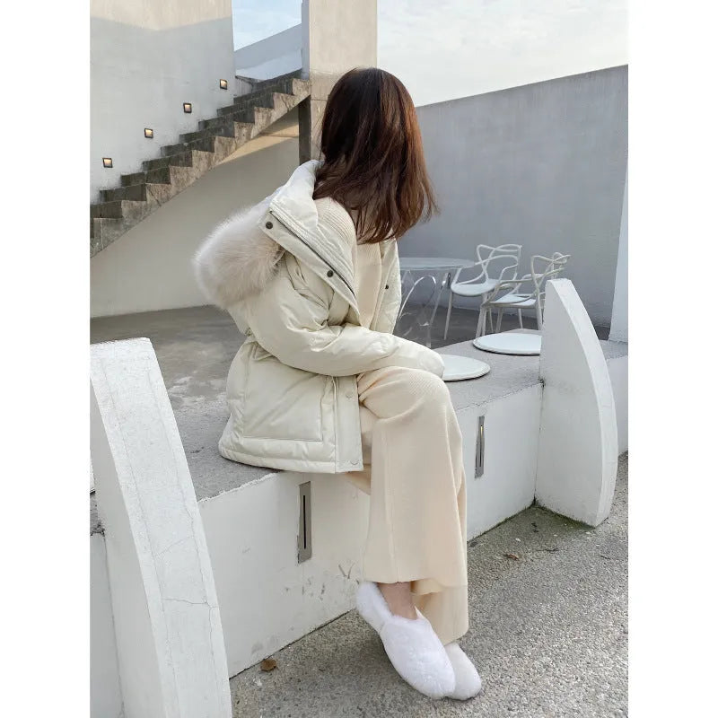 Woman wearing cream white knitted high-waist wide-leg winter trousers.