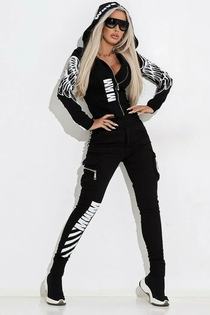 Black women's zip-up hoodie with wings print and matching casual trousers laid flat.