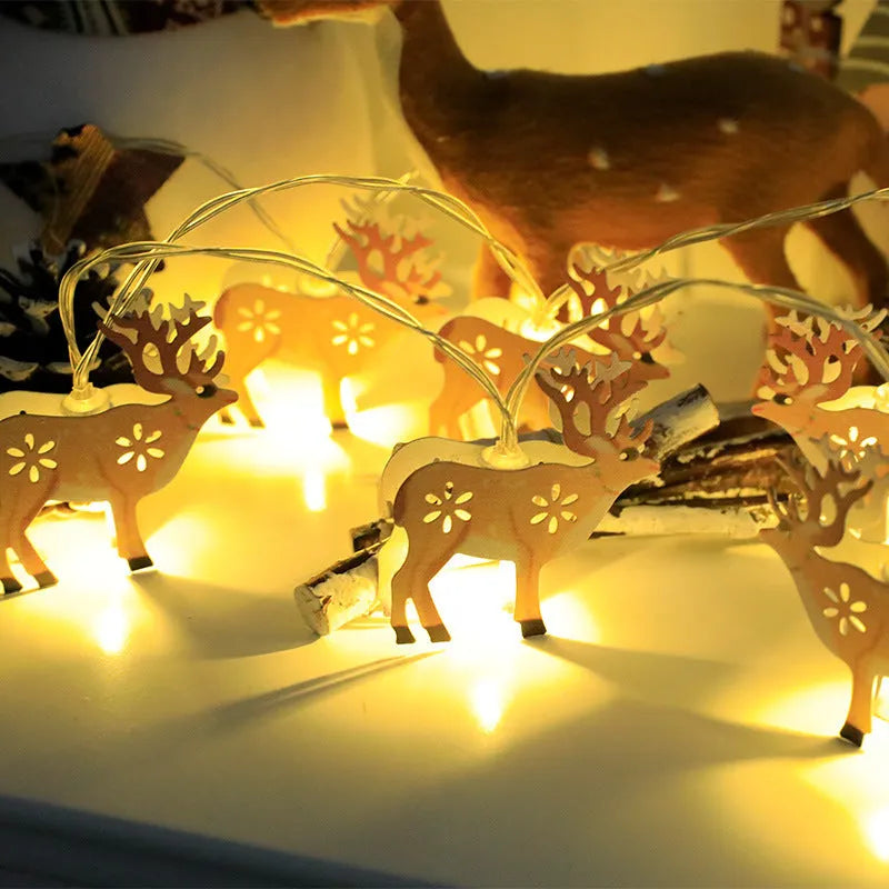 Christmas LED light string with Santa Claus, elk, and snowman ornaments hanging on pine branch