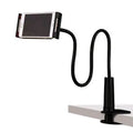 Black bedside oversize flat panel mobile phone stand with a long arm on a wooden table.