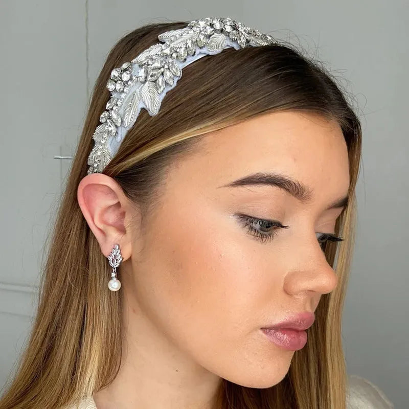 Geometric flower-shaped earrings with micro inlaid zircon and pearl details on a gold-toned metal base.