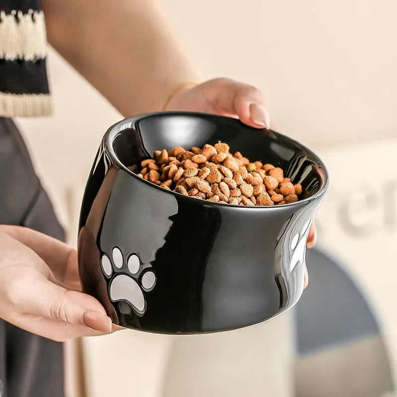 Ceramic cat bowl with cat paw design in black, showing oblique mouth style.