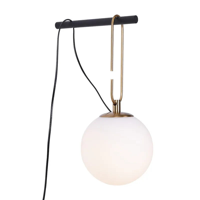 Modern Nordic-style glass wall lamp on a white wall, showing clean lines and translucent glass construction.