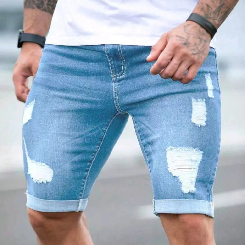 Sky blue men's denim shorts with multi-hole manual wear distressing and low waist straight cut