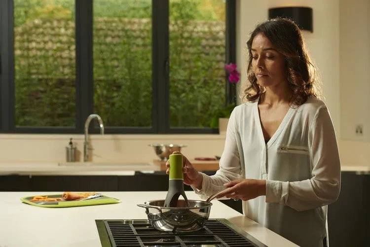 Uutensil Stirr automatic pot mixer device in green colour for hands-free stirring of sauces and soups.