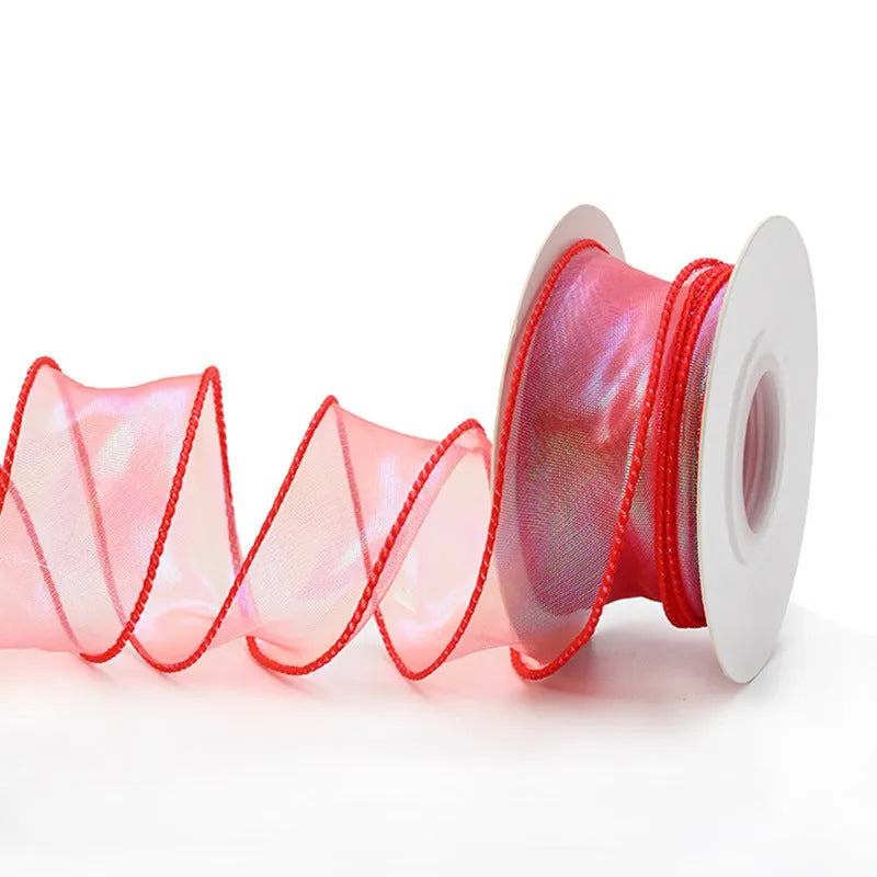 Roll of colourful fishtail yarn mesh ribbon showing its textured, wavy edge, with a colour selection including pink, yellow, and blue.