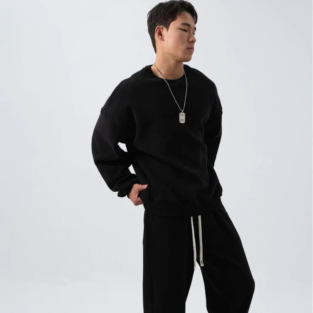 Men's black polar fleece sports suit set with long sleeve coat and loose trousers on a hanger.