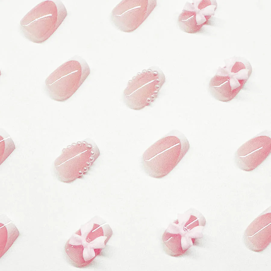 Set of 24 short square nail wraps with French tips and bow, tulip, and starry sky designs on a backing card.