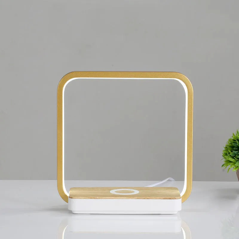 LED desk lamp with wireless charging base in round white finish on a wooden desk