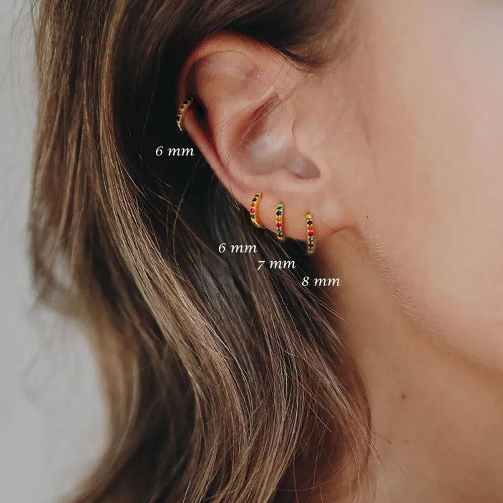 Geometric round perforated stud earrings in gold, rose gold, and silver colour on a white background.