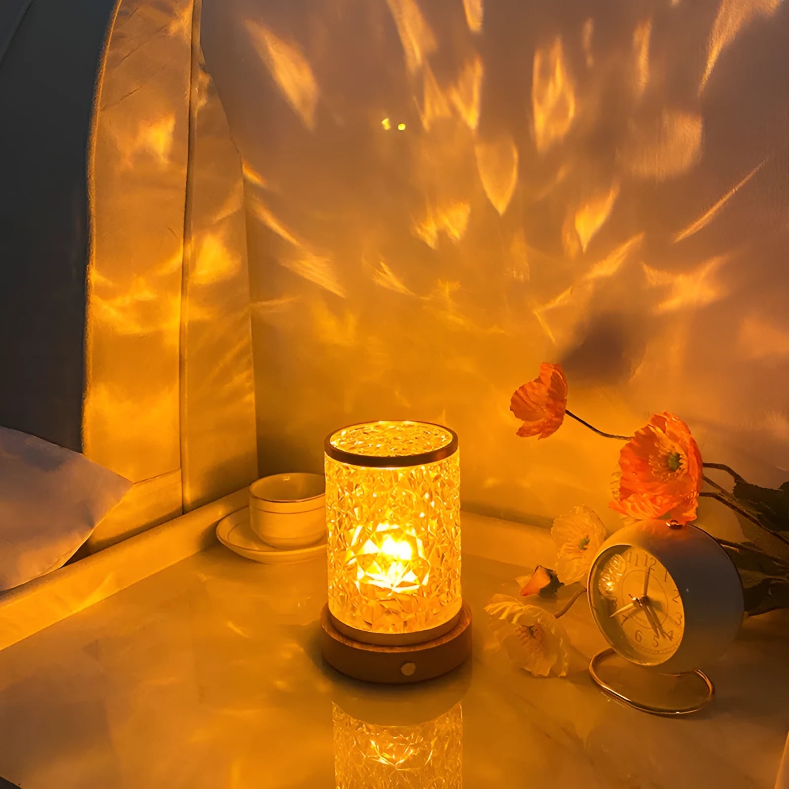 Small rotating water ripple night light with acrylic dome and solid wood base on a table.