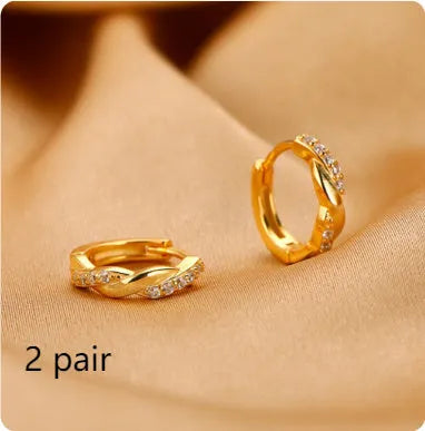 Close-up of women's geometric ear clips with interwoven hemp rope centre in gold tone.