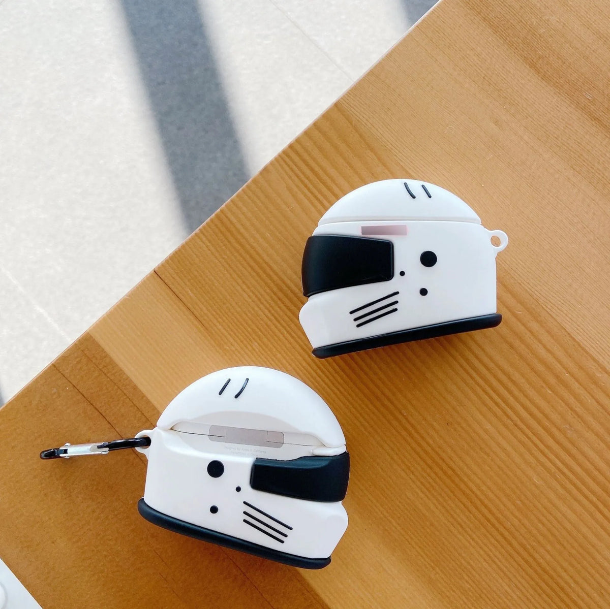 Silicone AirPods cover with motorcycle helmet shape, carabiner, and geometrical pattern, for AirPods Pro and AirPods 1/2.