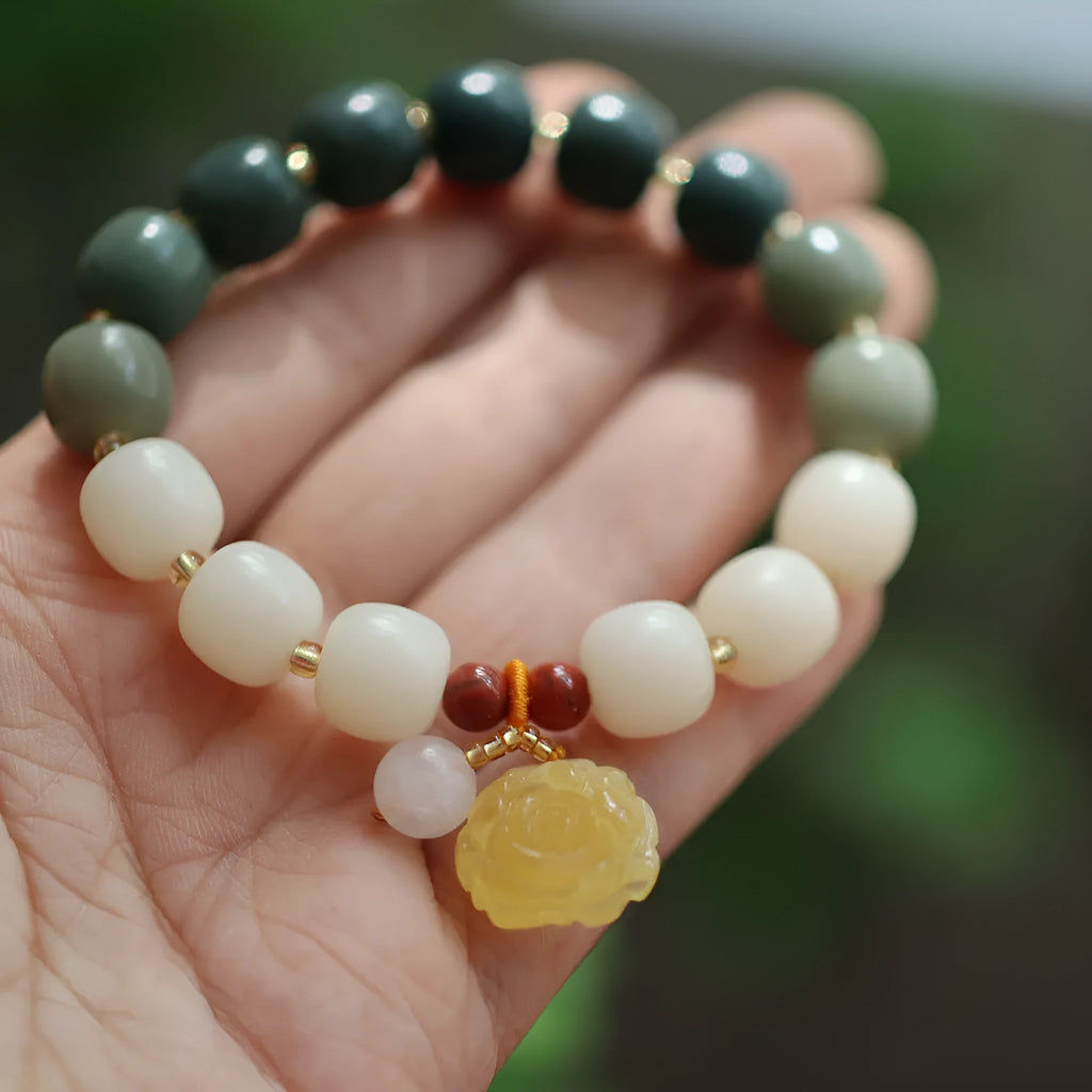 Women's Bodhi root bracelet with gradient white jade beads and a natural beeswax lotus pendant.