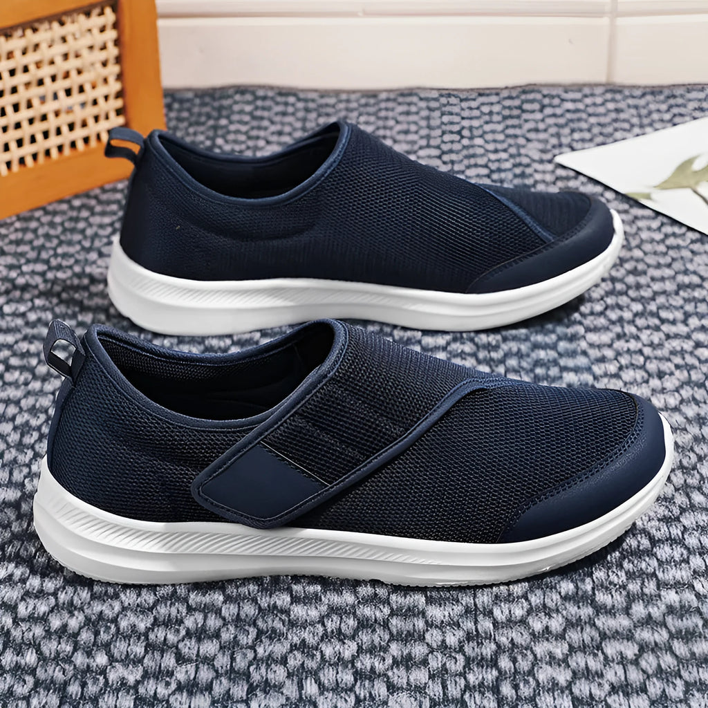 A pair of casual walking shoes with a mesh upper and Velcro strap closure, shown in one of four available colours.