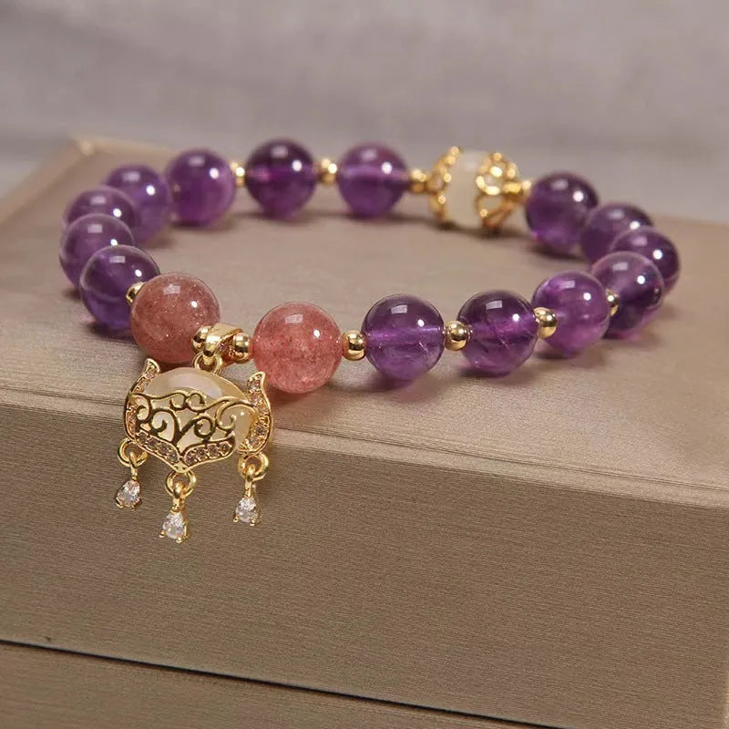 Women's copper bracelet with natural amethyst stones, gold accents, and a longevity lock charm