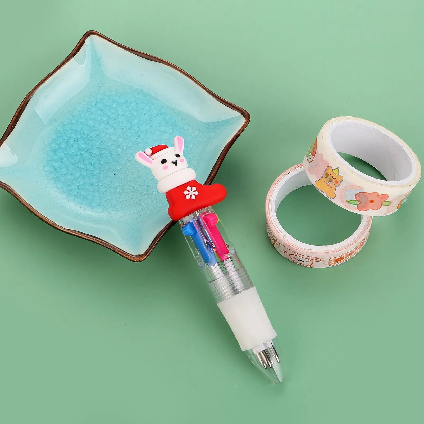 Compact 11cm Christmas ballpoint pen with four colours and festive designs like snowmen and reindeer.