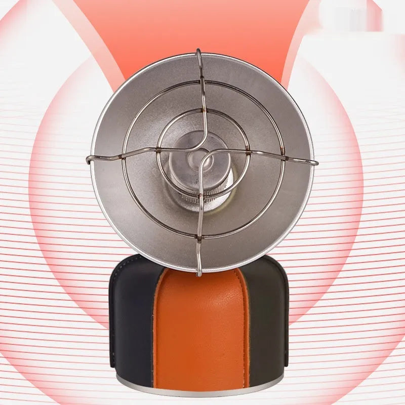 Black and orange portable camping heater stove with automatic ignition on a rocky outdoor surface.