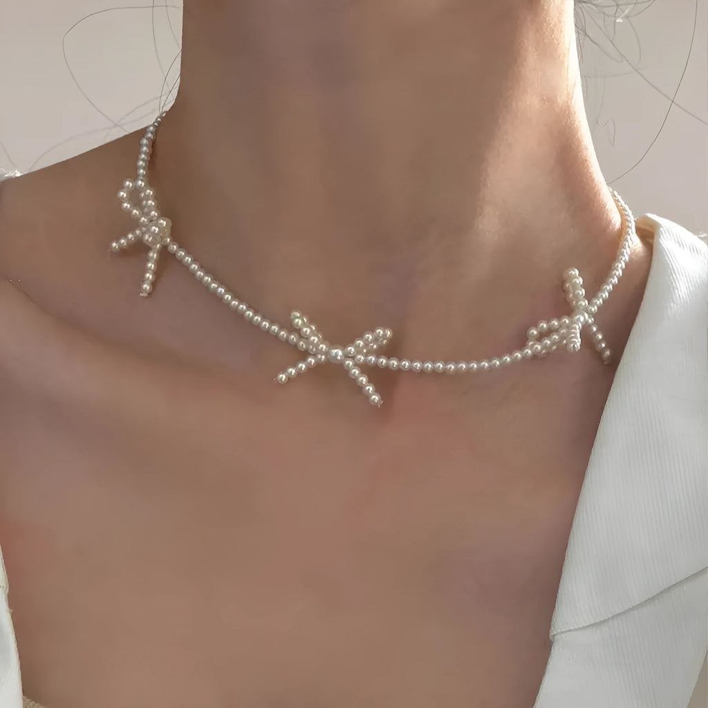 Women's white imitation pearl necklace with sweet bow design and geometric shapes on adjustable chain