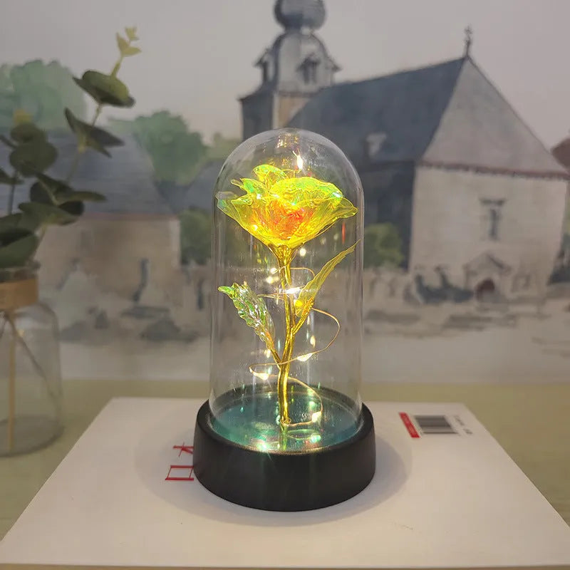 Small decorative night lamp with plastic flowers and a glass-style cover on a black base.
