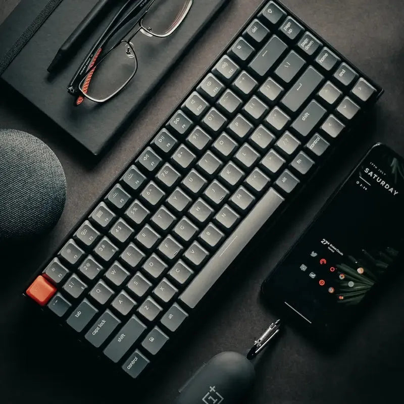 Plastic edge 87-key mechanical keyboard with white LED backlighting, grey colour, showing keycaps and USB cable