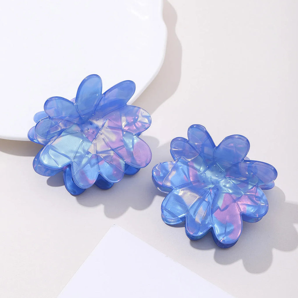 Dazzling blue PVC flower hair clip with glossy finish, 6cm length, on a light background