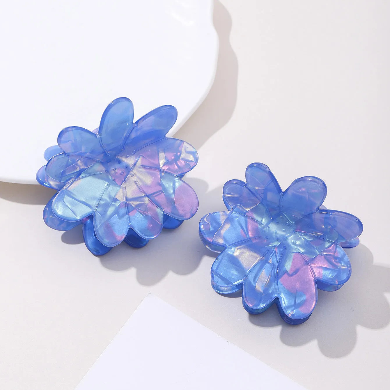 Dazzling blue PVC flower hair clip with glossy finish, 6cm length, on a light background