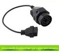 BMW 20-pin male to standard 16-pin OBD2 female diagnostic adapter cable on a workshop bench.