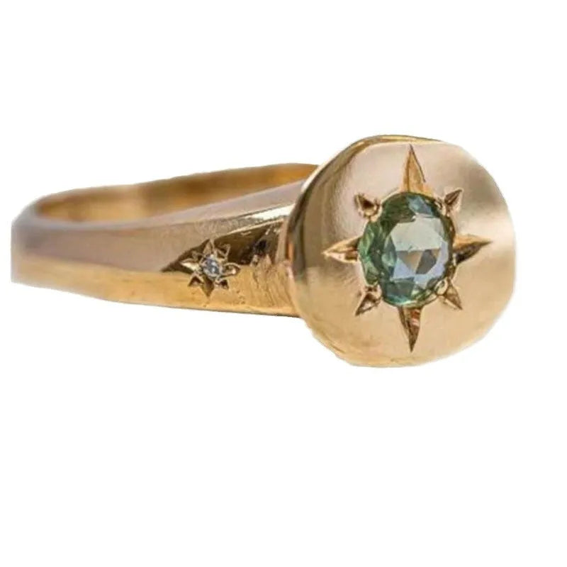 Golden adjustable ring with a star-shaped setting holding an oval zircon stone on a zinc alloy band.