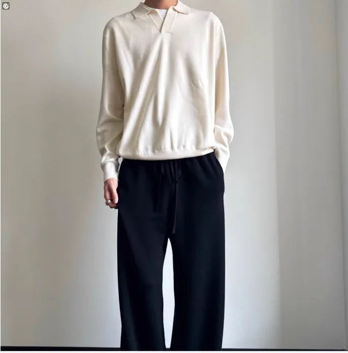 Milky white pure wool lapel collar polo sweater laid flat, showing loose fit and long sleeves.