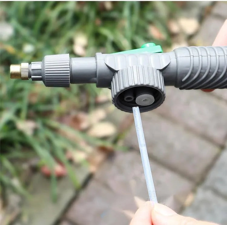 Plastic watering sprayer nozzle with extension tube attached to a large clear beverage bottle.