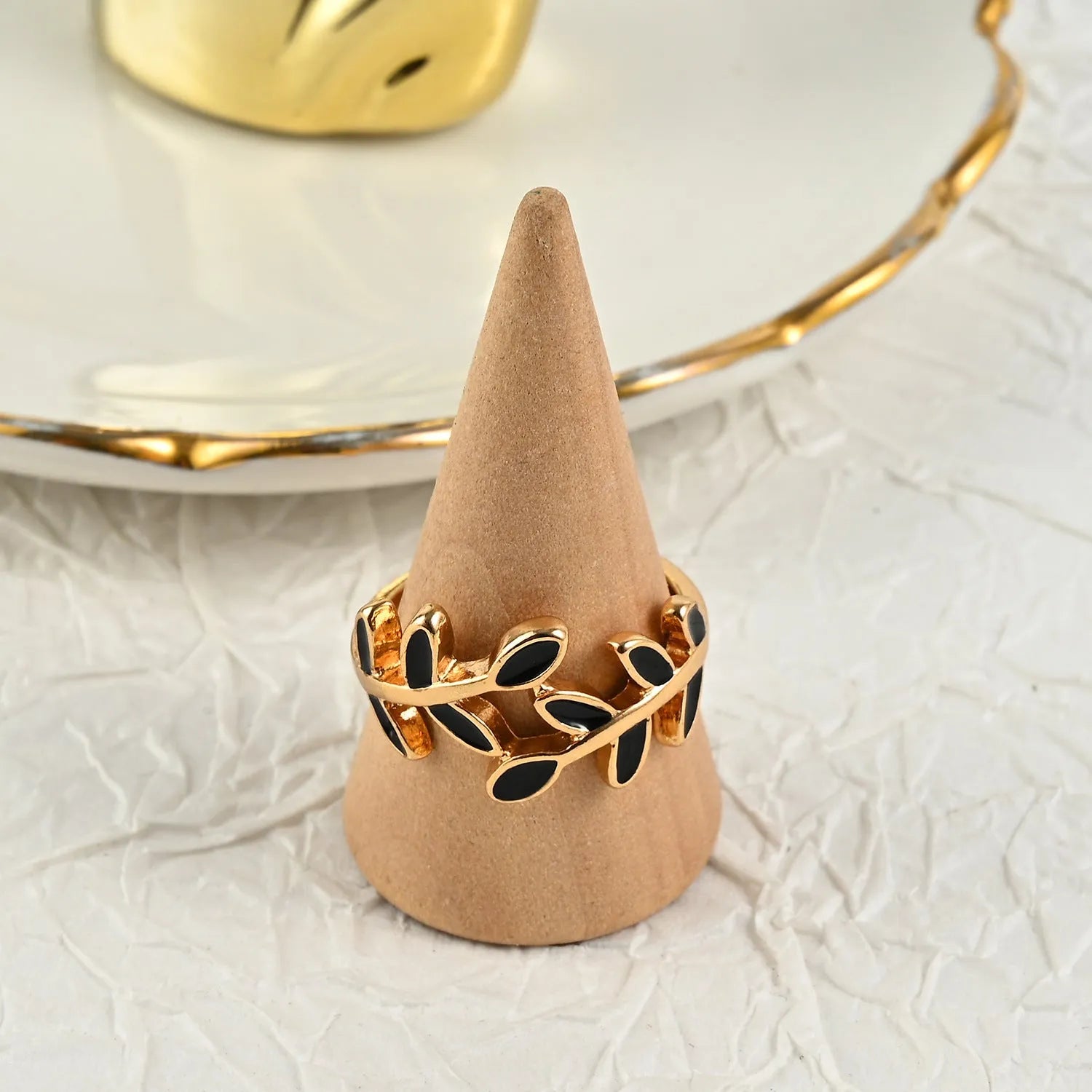 Geometric leaf ring with gold electroplated finish and simple floral design on finger