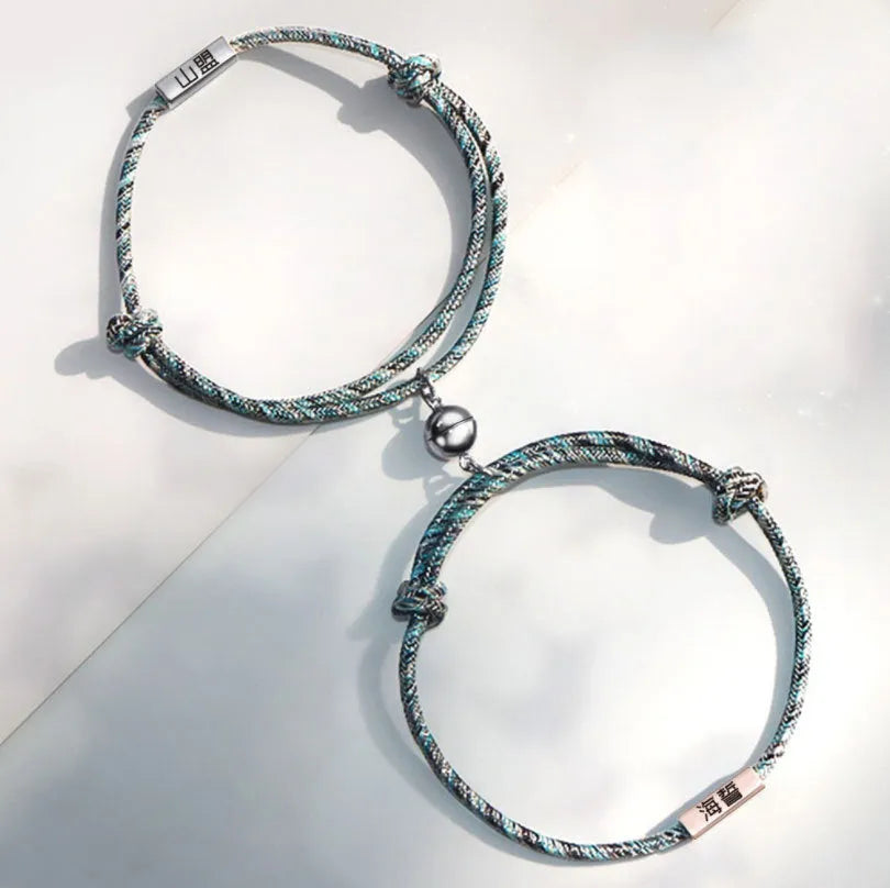 Pair of stainless steel magnetic bracelets for couples, silver and rose gold finish, with adjustable hand rope