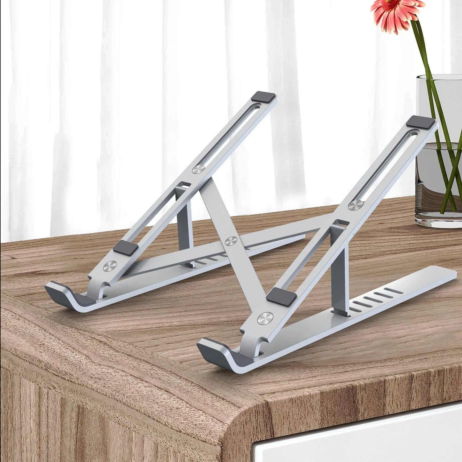 Silver aluminium laptop stand showing six height adjustment positions in folded configuration