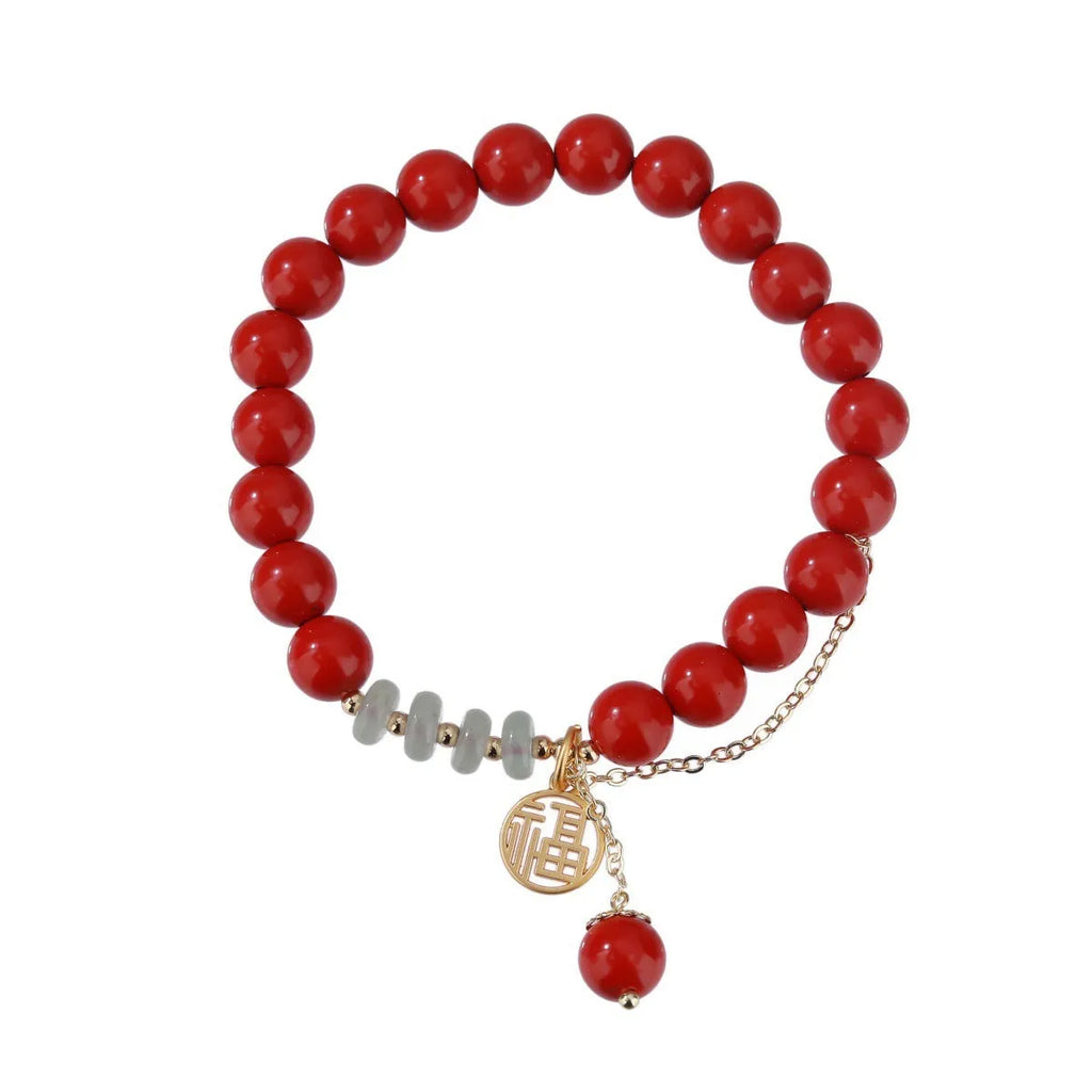 Women's handmade cinnabar bracelet with fu character charm, jade spacer beads, and red sand tassel detail