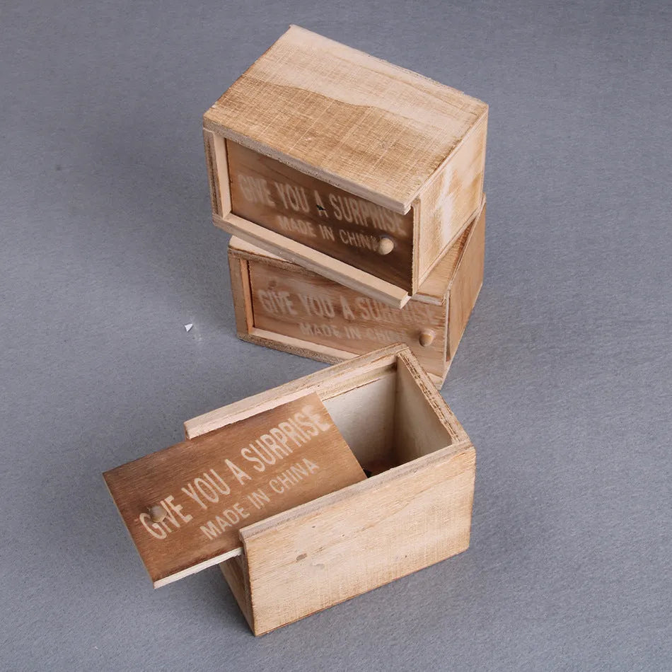 Wooden prank scare box closed, with a lifelike jumping spider toy next to it.